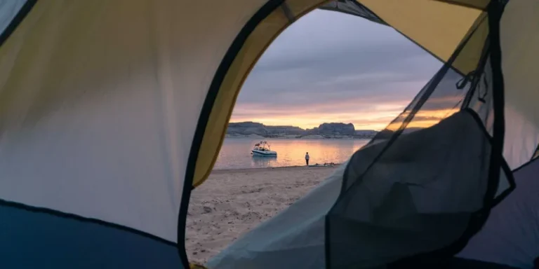 Tent view of a beach with a boat at sunset