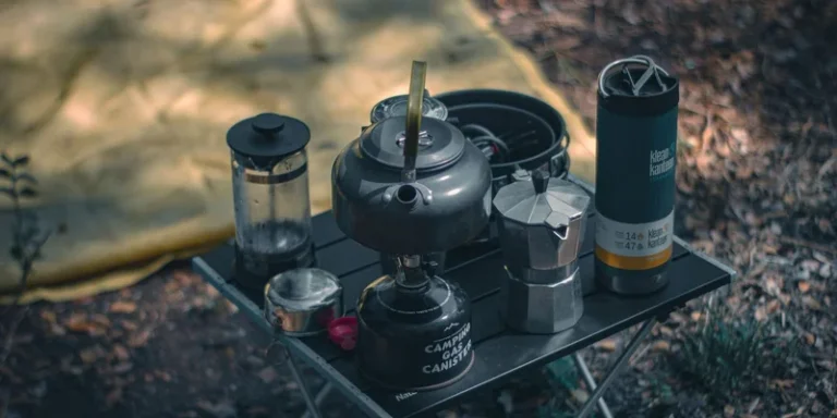 A cozy camping setup featuring coffee-making equipment and a tent outdoors