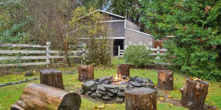 Cozy outdoor fire pit with log stools in a tranquil backyard setting