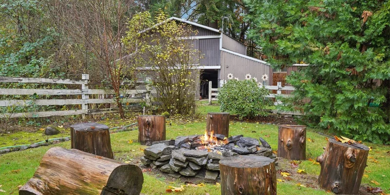 Cozy outdoor fire pit with log stools in a tranquil backyard setting