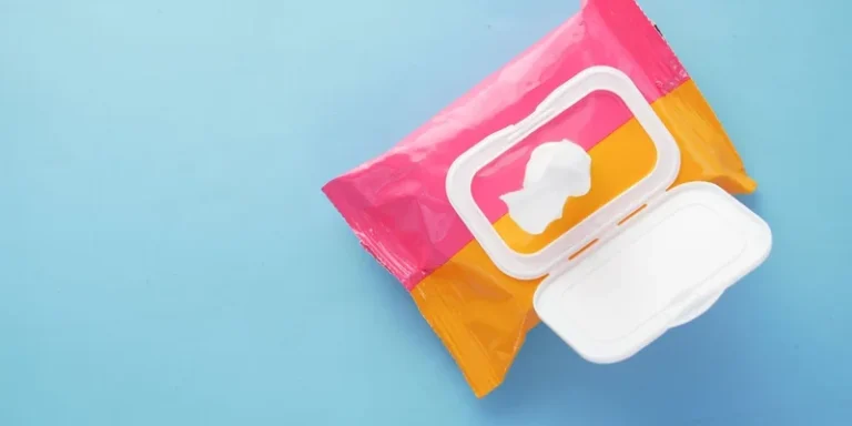Brightly colored wet wipes package on a blue surface, symbolizing hygiene and cleanliness