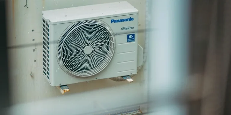 Air conditioner unit mounted outdoors on a building wall