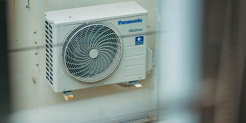 Air conditioner unit mounted outdoors on a building wall