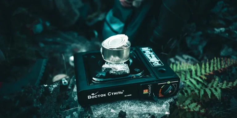 A portable gas stove heating a canned meal outdoors