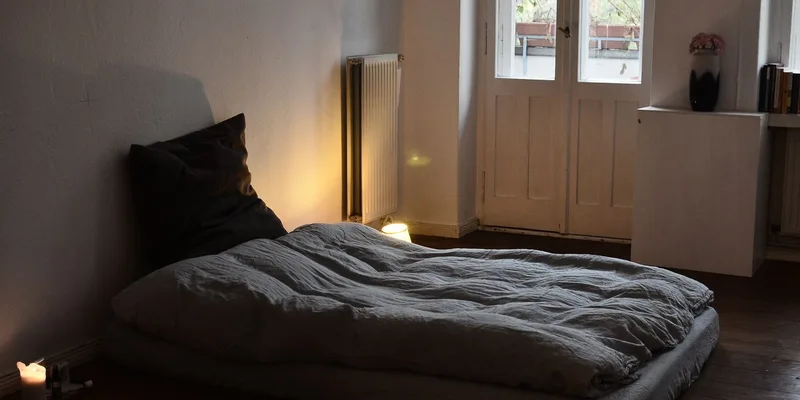 A serene bedroom ambiance with a mattress on the floor and glowing candlelight